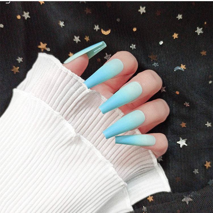 fingers wearing blue ombre nails and white sleeves
